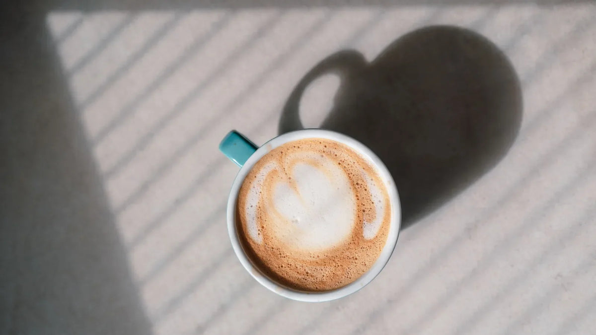 Cappuccino met een hartvormige latte art in het licht van de ochtend.